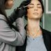 Testimonio Software para salones de cejas y pestañas N&M 1 A beautician carefully shapes a woman's eyebrows in a modern salon setup.